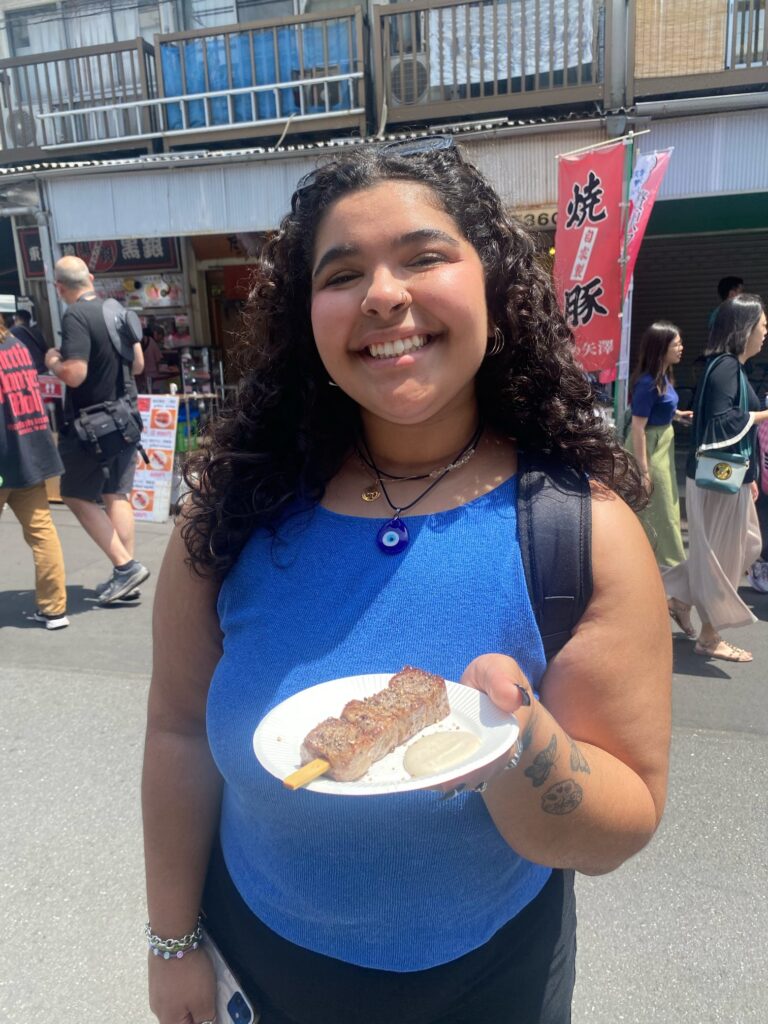 Maya Hicks holds a plate of Wagyu beef steak in the Tsukiji Outer Market